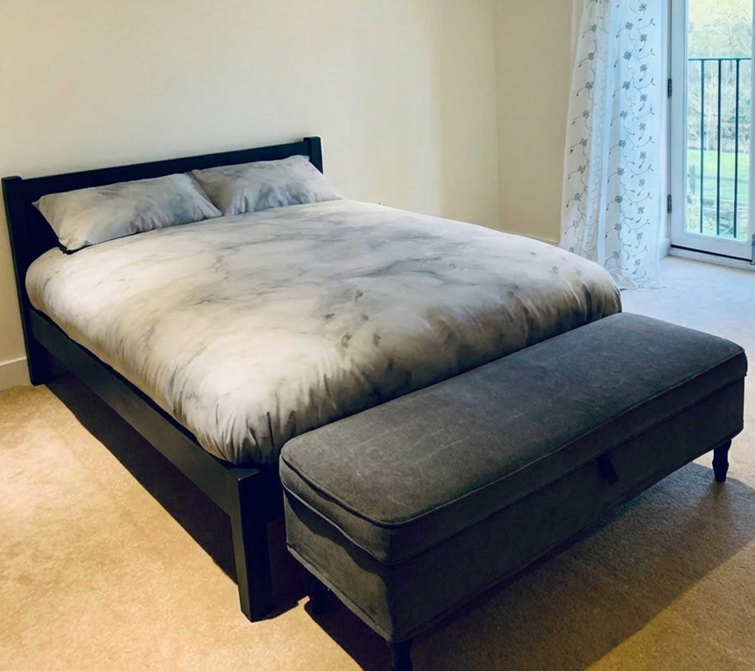 Cadre de lit en bois noir dans une chambre crème et noir